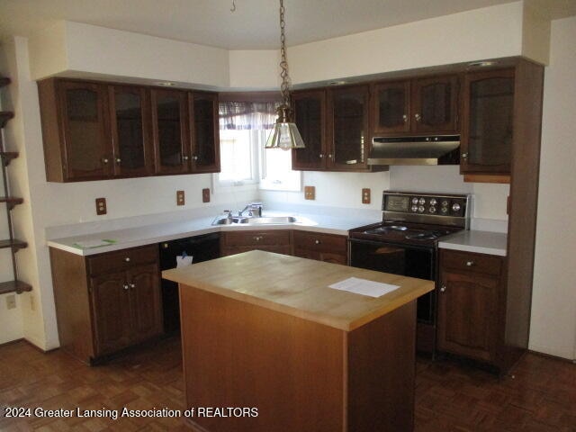 kitchen featuring dark brown cabinets, black range with electric cooktop, sink, pendant lighting, and a kitchen island