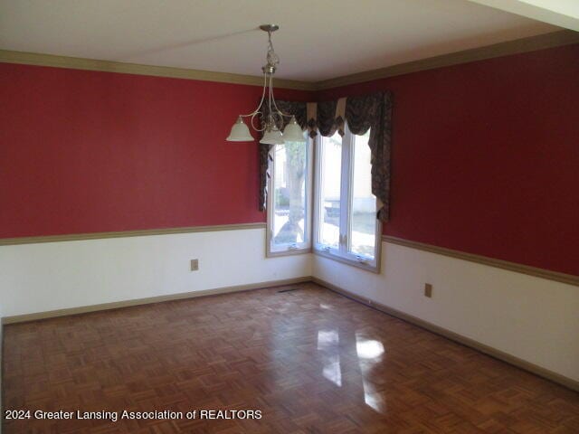 empty room with parquet flooring and crown molding