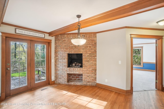 unfurnished living room featuring hardwood / wood-style flooring, a fireplace, crown molding, and beam ceiling