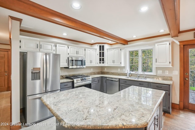 kitchen featuring white cabinets, appliances with stainless steel finishes, a kitchen island, and sink