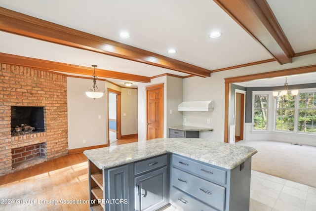 kitchen with light stone countertops, hanging light fixtures, light hardwood / wood-style floors, and a center island