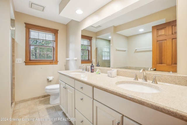 bathroom featuring tile patterned floors, a shower with shower door, vanity, and toilet