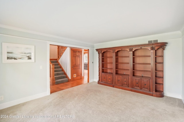 unfurnished living room with light colored carpet and ornamental molding