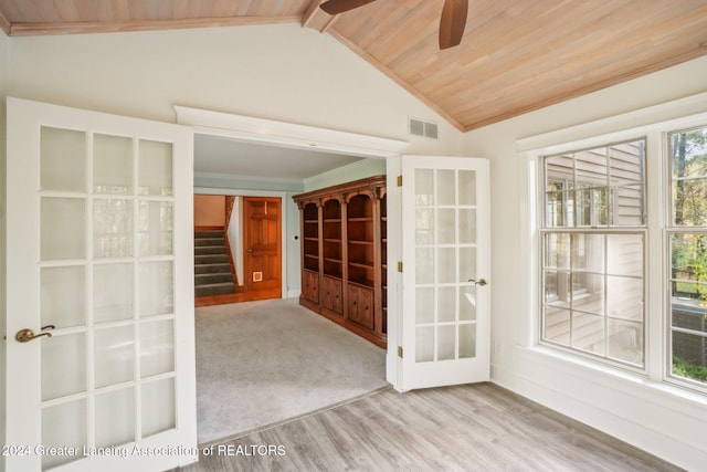 empty room featuring ceiling fan, wooden ceiling, light hardwood / wood-style flooring, french doors, and vaulted ceiling with beams