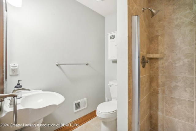 bathroom featuring sink, tile patterned flooring, toilet, and a shower with door