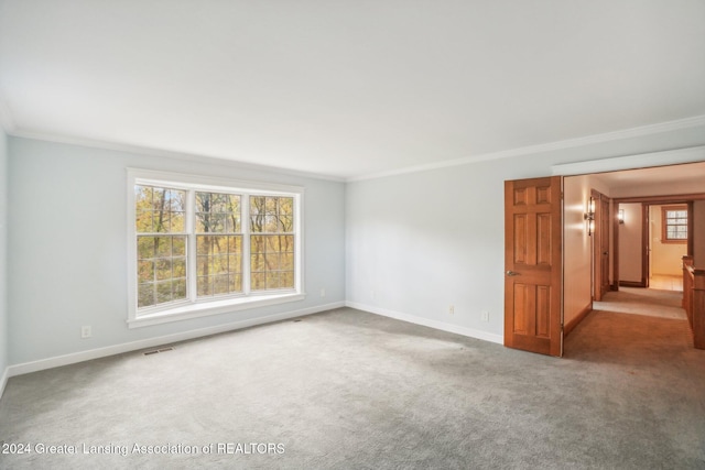 carpeted empty room featuring crown molding