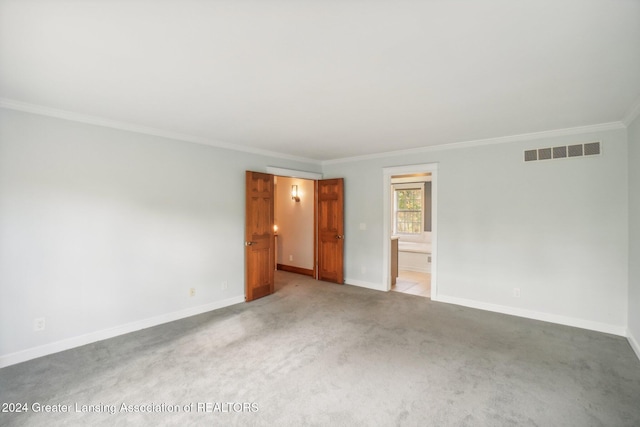 empty room featuring ornamental molding and light colored carpet