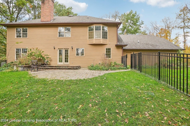 back of property with a patio and a lawn