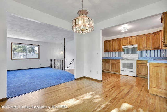 kitchen with light hardwood / wood-style floors, tasteful backsplash, white electric stove, and hanging light fixtures