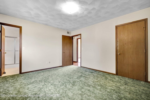 unfurnished bedroom featuring a closet, a textured ceiling, and light colored carpet