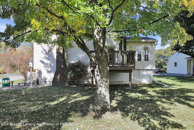 rear view of property with a wooden deck and a lawn