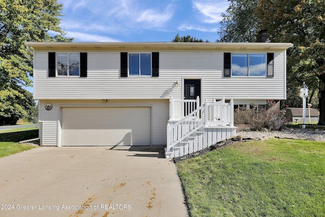 bi-level home featuring a garage and a front lawn