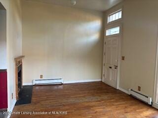 unfurnished living room featuring a baseboard radiator and hardwood / wood-style flooring