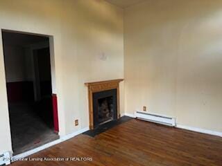 unfurnished living room with baseboard heating and dark wood-type flooring