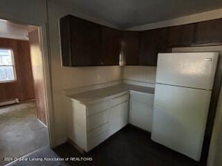 kitchen featuring dark brown cabinets and white refrigerator