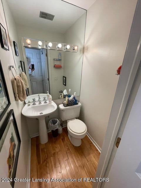 bathroom with toilet and hardwood / wood-style floors