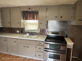 kitchen featuring sink, stainless steel electric range oven, and light wood-type flooring