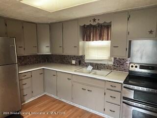 kitchen featuring decorative backsplash, light hardwood / wood-style flooring, electric stove, sink, and white refrigerator