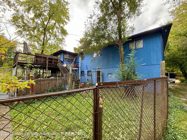 back of property featuring a wooden deck and a yard