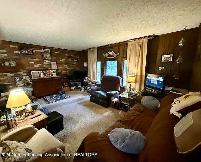 living room with carpet flooring, a textured ceiling, and wood walls