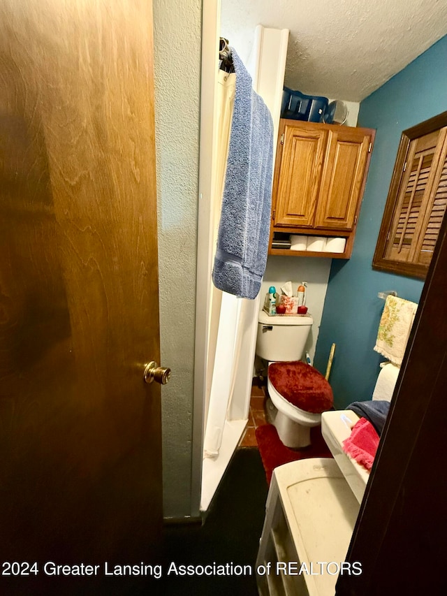 bathroom featuring toilet and a textured ceiling