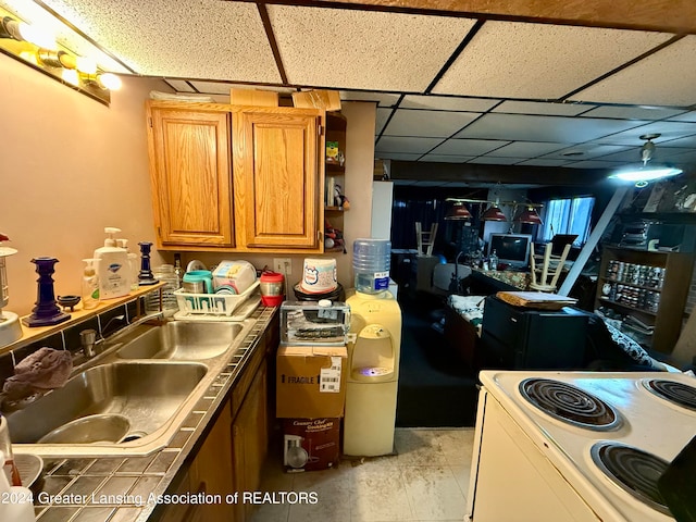 kitchen with a drop ceiling, sink, and white range with electric stovetop