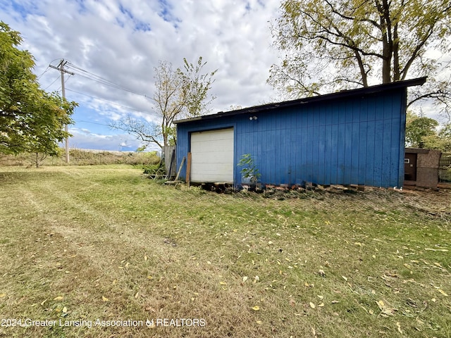 view of outdoor structure featuring a garage and a yard