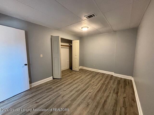 unfurnished bedroom with dark hardwood / wood-style floors and a closet