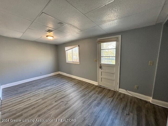 spare room with a paneled ceiling and hardwood / wood-style flooring