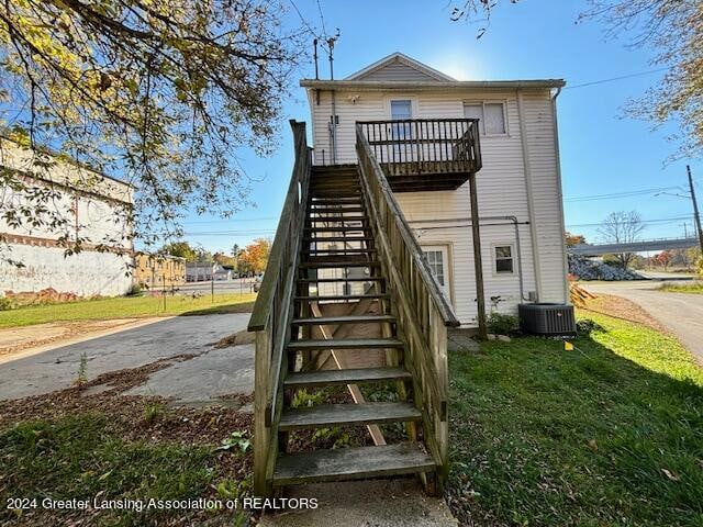 rear view of house featuring a yard, a deck, and cooling unit