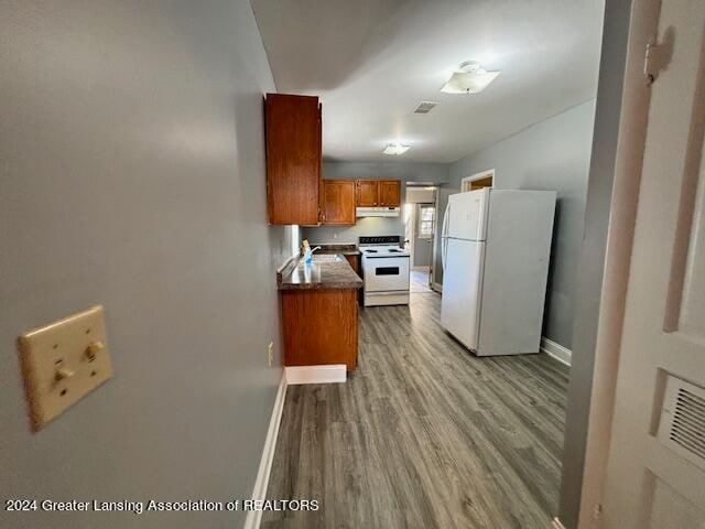 kitchen with light hardwood / wood-style floors and white appliances