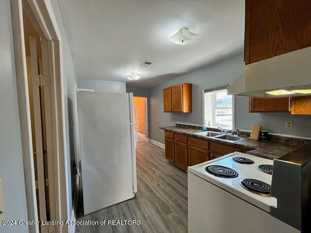 kitchen featuring white appliances, light hardwood / wood-style flooring, and sink