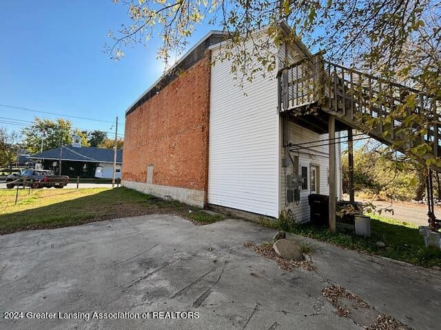 view of side of property with a wooden deck and a lawn