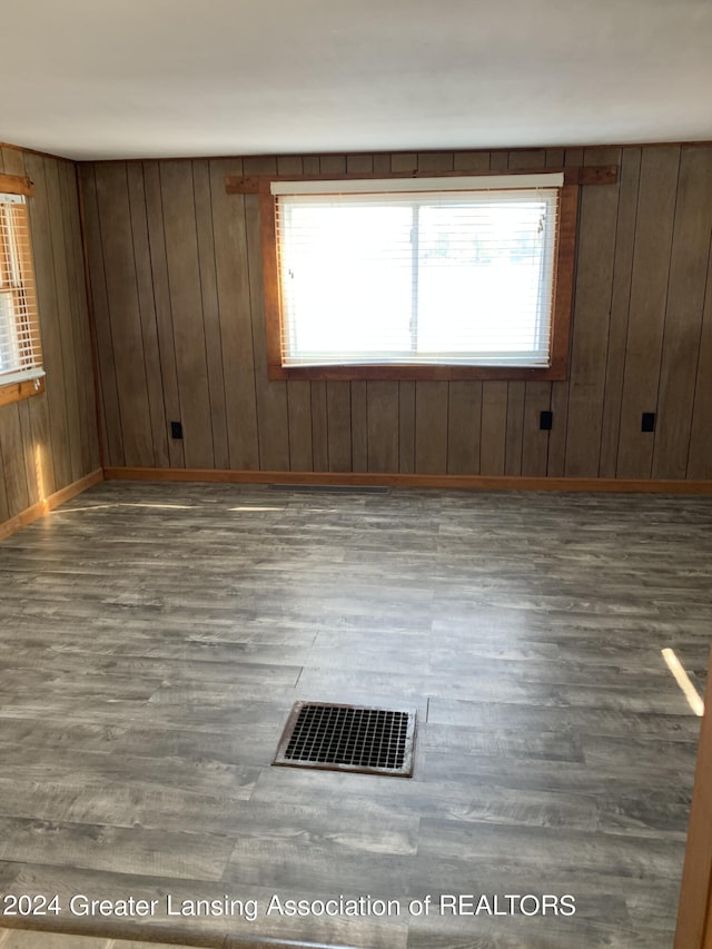 empty room featuring dark hardwood / wood-style floors and wood walls