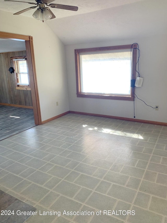 unfurnished room featuring lofted ceiling, ceiling fan, and plenty of natural light