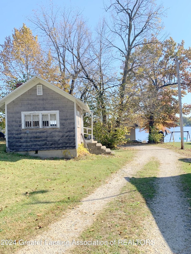 view of home's exterior with a lawn and an outdoor structure