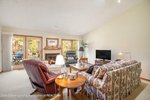 living room with a textured ceiling, light colored carpet, and plenty of natural light