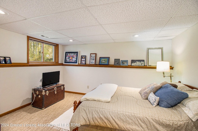 bedroom with light carpet and a paneled ceiling