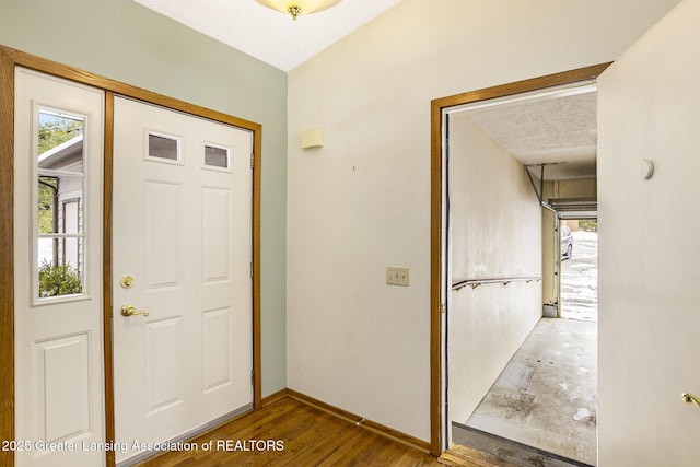 foyer entrance with wood finished floors and baseboards