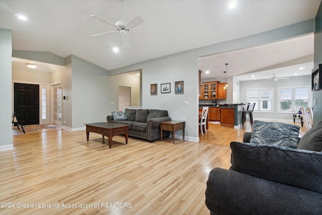 living room featuring light hardwood / wood-style floors, lofted ceiling, and ceiling fan