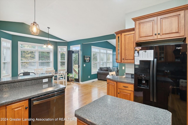 kitchen featuring lofted ceiling, a healthy amount of sunlight, light wood-type flooring, and black fridge