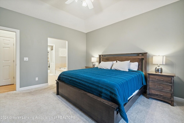 bedroom with light colored carpet, connected bathroom, and ceiling fan