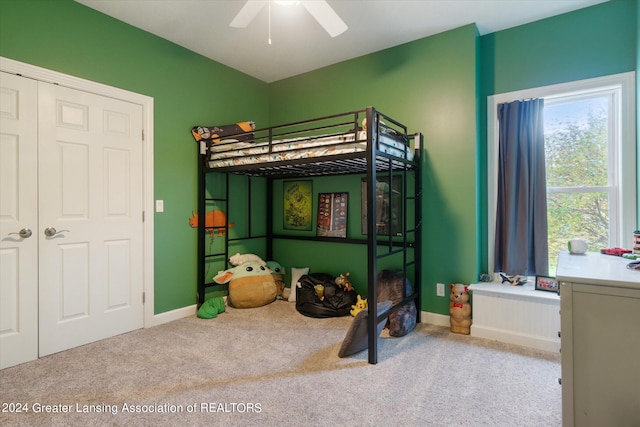 bedroom with a closet, light colored carpet, and ceiling fan