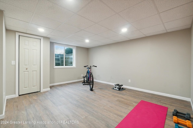 exercise area featuring light hardwood / wood-style flooring and a drop ceiling