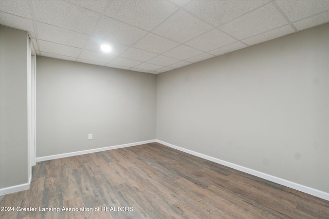 spare room featuring a drop ceiling and hardwood / wood-style floors