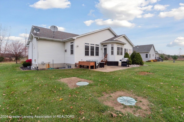 rear view of house featuring a yard and a patio area