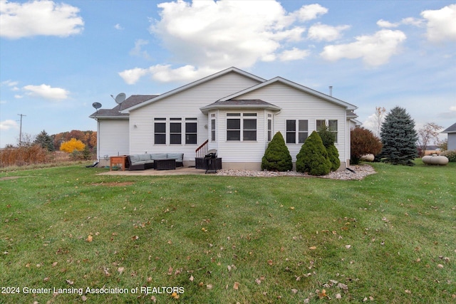 back of property with a patio, an outdoor living space, and a yard