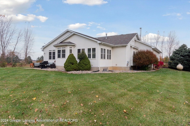 rear view of house featuring a yard and a patio