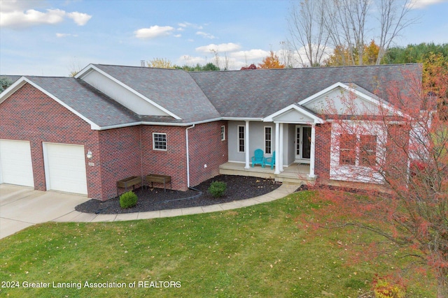 view of front facade featuring a front yard, a garage, and covered porch