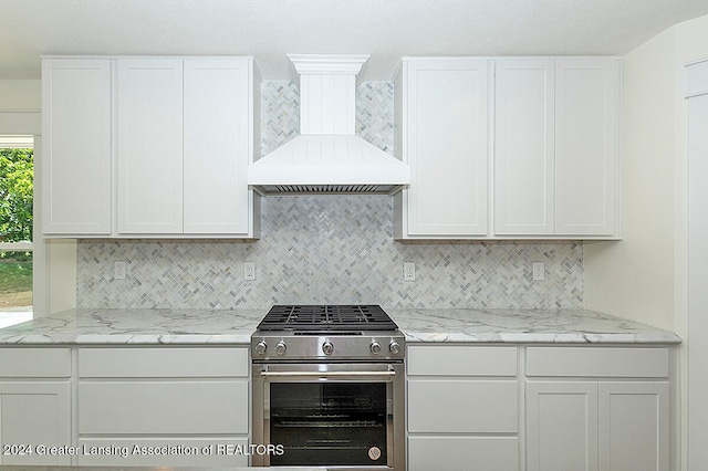 kitchen with white cabinets, custom range hood, and high end stainless steel range oven